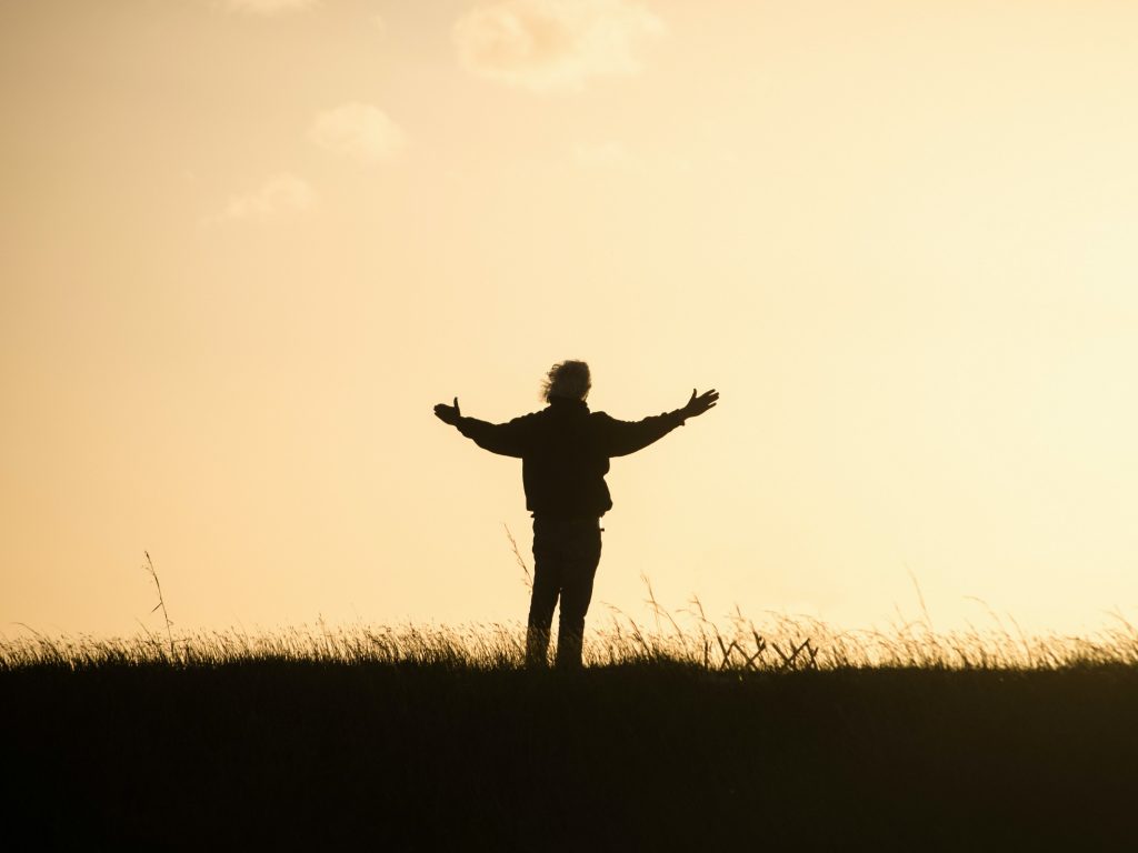 A man holding his arms up in gratitude